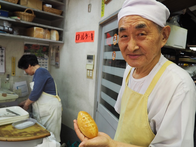 ▲手づくりパンの店「フォーレ」店主、78歳のベテランパン職人、持田寿穂さん。「トライくんカレー」は手のひらにおさまるかわいいサイズ
